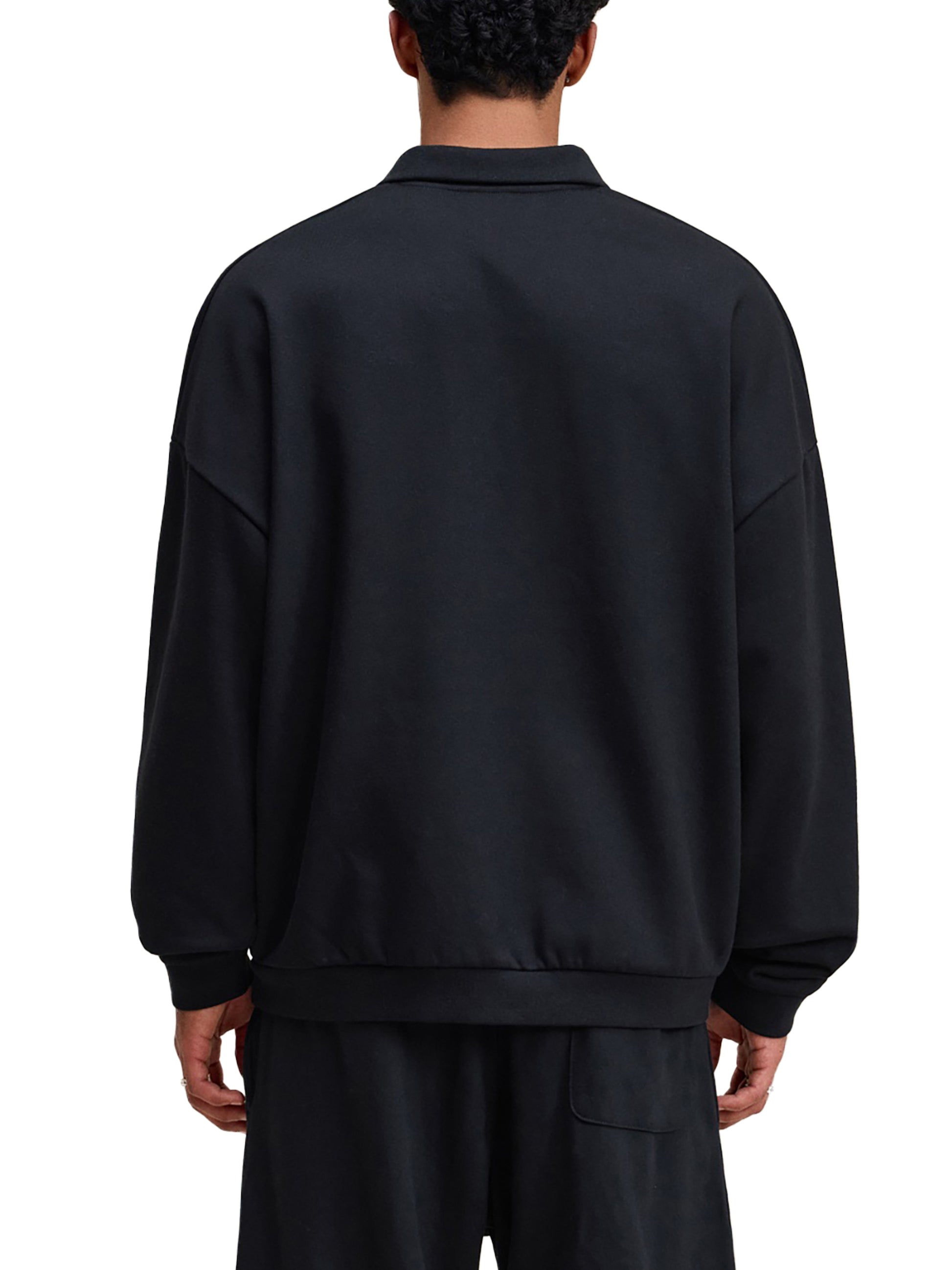 Person wearing a black tracksuit on a white background