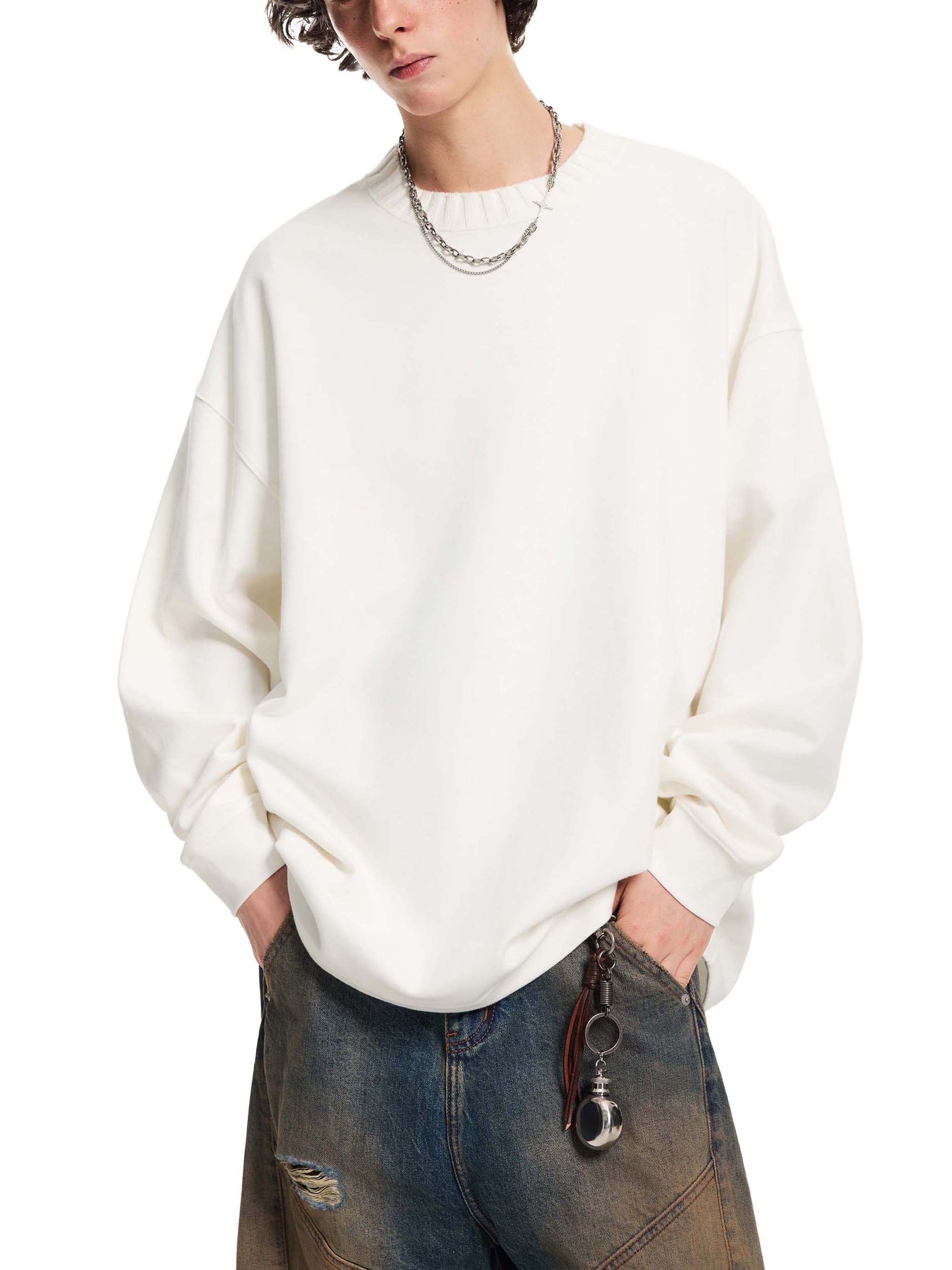 Person wearing a white sweater and jeans on a white background